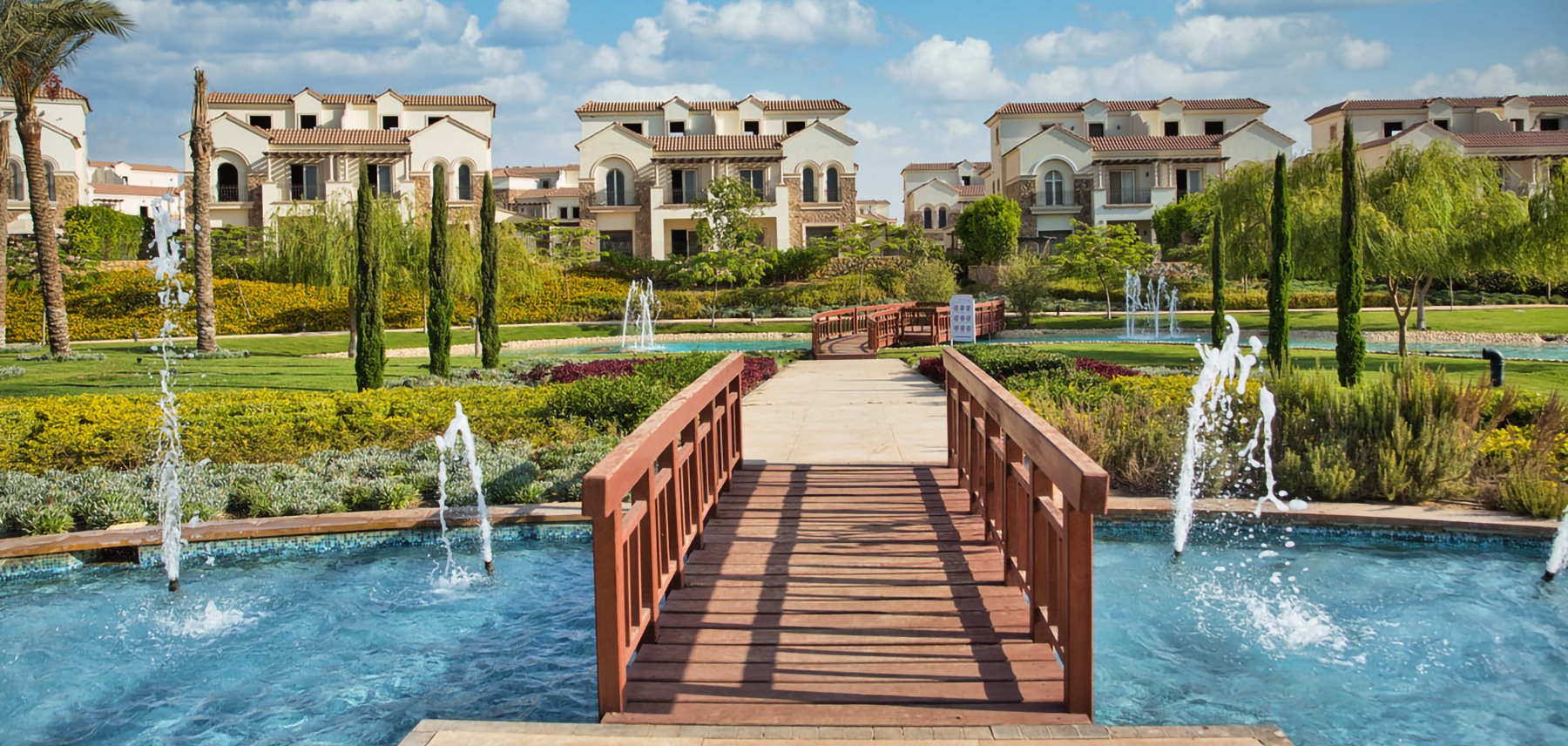 جسر مشاة ونوافير داخل Divina Gardens